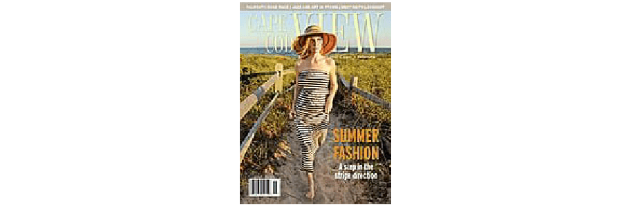 A woman wearing a striped swimsuit and wide-brimmed hat walks along a beach path on the cover of a summer fashion magazine.