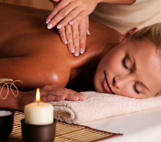 A woman gets a massage by candle light