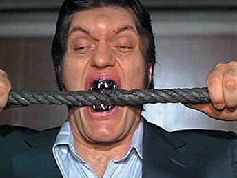 man with wicked looking teeth biting cable