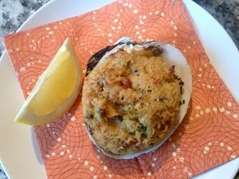 Photo of plate of stuffed clams with slide of lemon